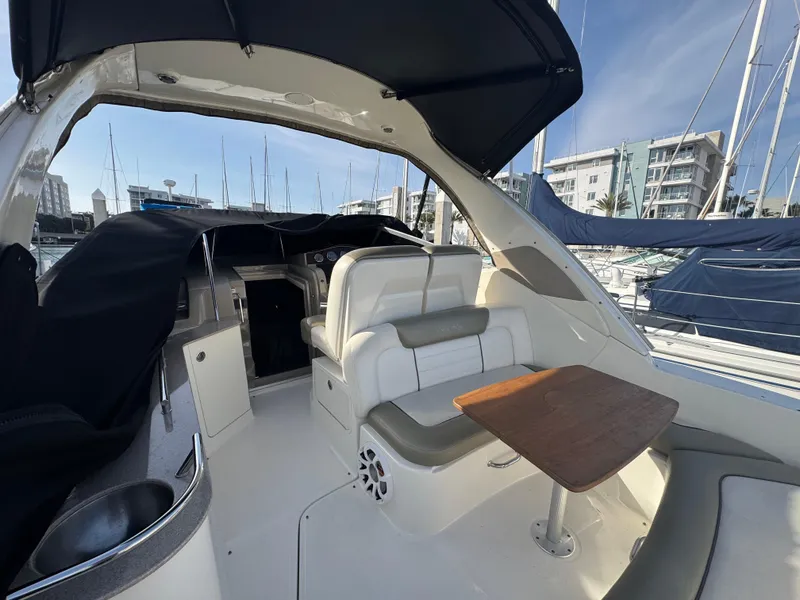 Slide: The Image of 2007 Sea Ray 310 Sundancer yacht interior with seating and table, docked at marina. - 6
