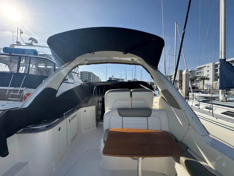 Slide: The Image of 2007 Sea Ray 310 Sundancer yacht interior with seating and table, docked at marina. - 8
