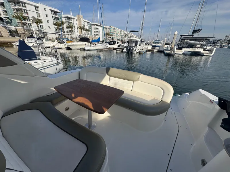 Slide: The Image of 2007 Sea Ray 310 Sundancer yacht interior with marina view, featuring comfortable seating and table. - 9