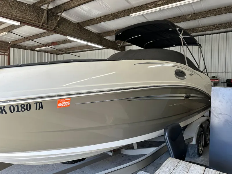 Slide: The Image of 2007 Sea Ray 260 Sundeck boat in storage, beige hull, black canopy, on trailer. - 6