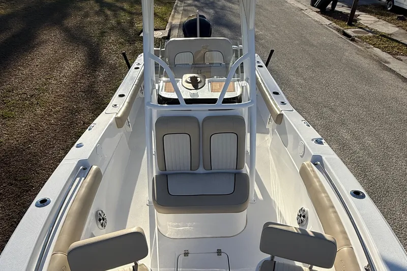 Slide: The Image of 2017 Sea Fox 246 Commander boat interior with seating and console, parked on a street. - 18
