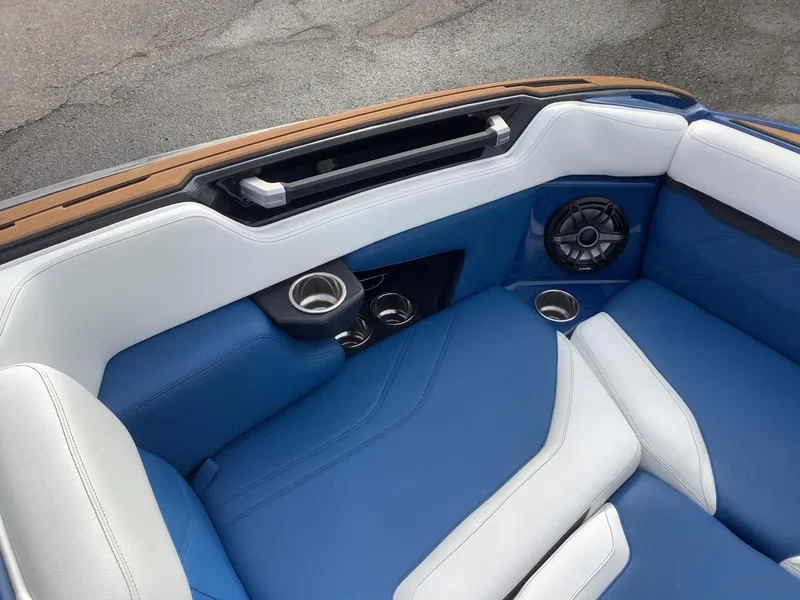 Slide: The Image of Interior of a 2023 Supra SE boat with blue and white seating. - 25