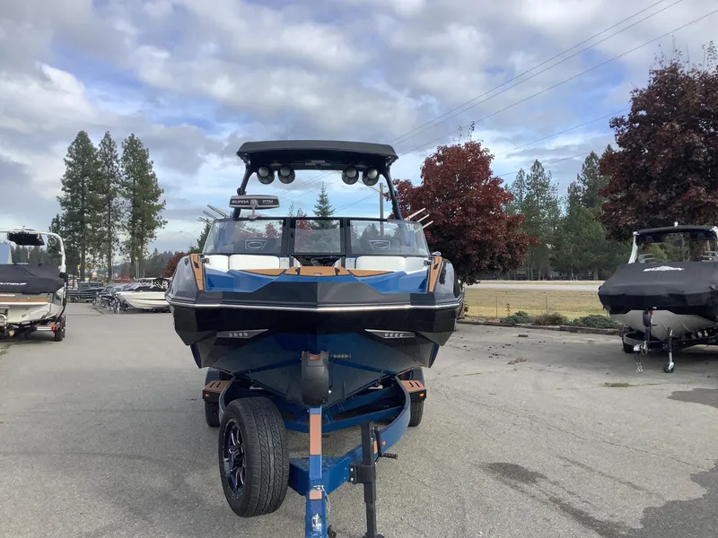 Slide: The Image of 2023 Supra SE boat on trailer in front of building. - 3