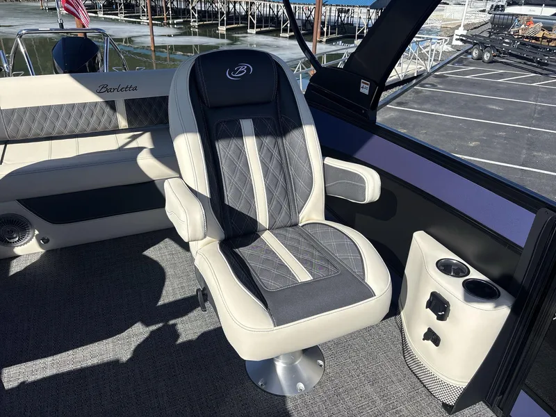 Slide: The Image of 2025 Barletta Lusso L23UC boat interior with luxury seating and cup holders. - 13