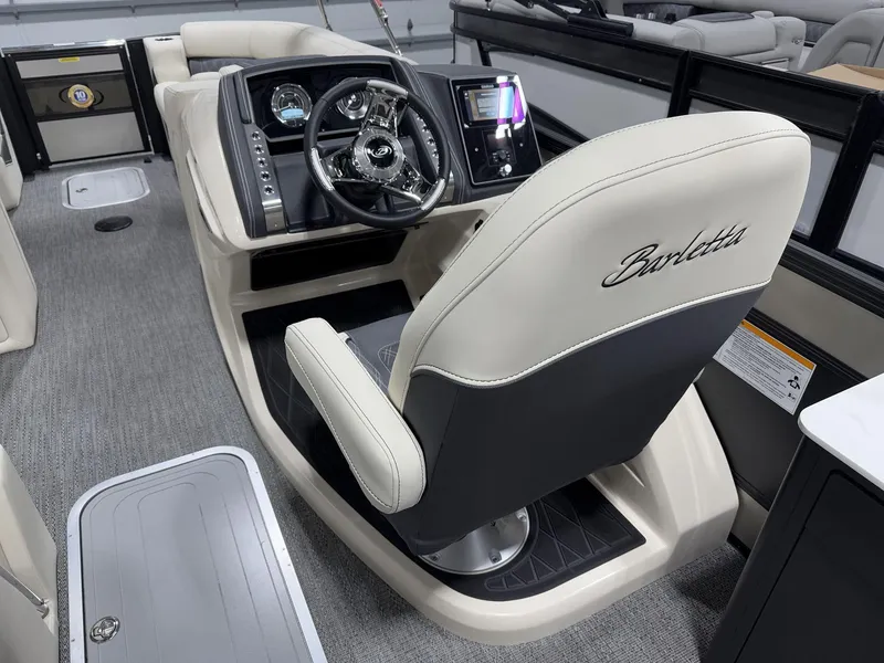 Slide: The Image of 2025 Barletta Lusso L25UEA boat interior with steering wheel and captain's chair. - 10