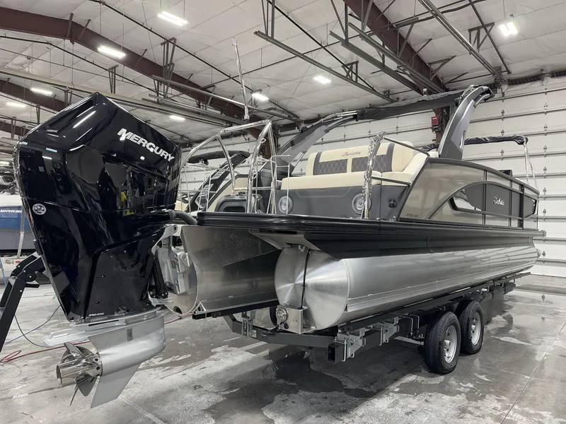 Slide: The Image of 2025 Barletta Lusso L25UEA pontoon boat with Mercury engine in a warehouse setting. - 4
