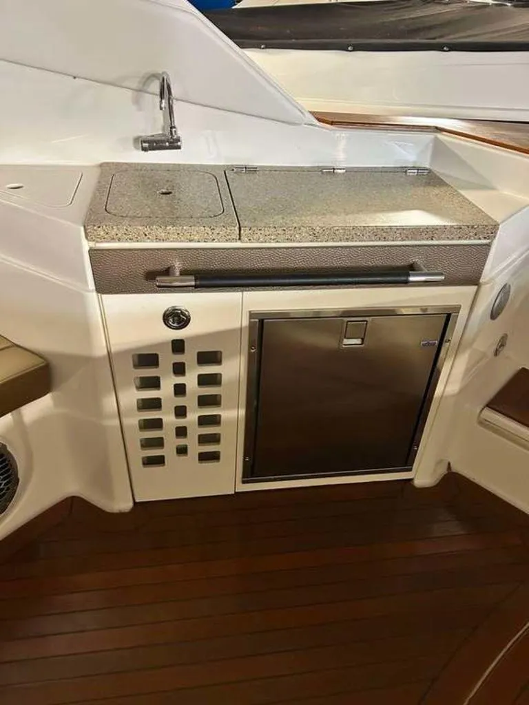 Slide: The Image of Interior of 2015 Sea Ray 350 SLX boat with kitchenette and wooden flooring. - 15