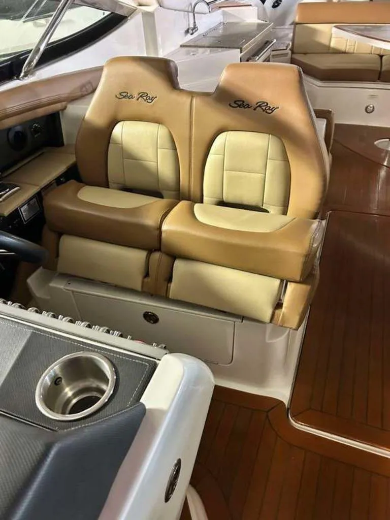 Slide: The Image of 2015 Sea Ray 350 SLX boat interior with tan leather seats and wood flooring. - 2