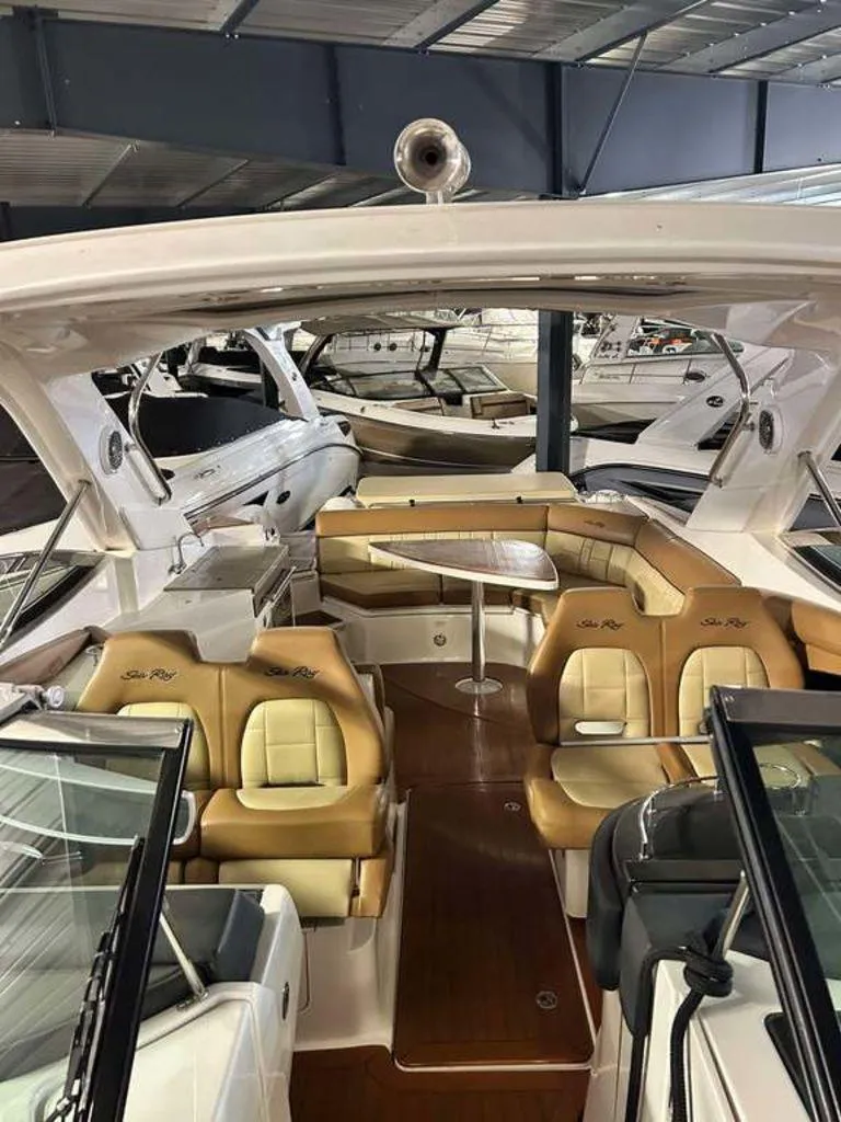 Slide: The Image of 2015 Sea Ray 350 SLX boat interior with tan seating and wooden flooring. - 6