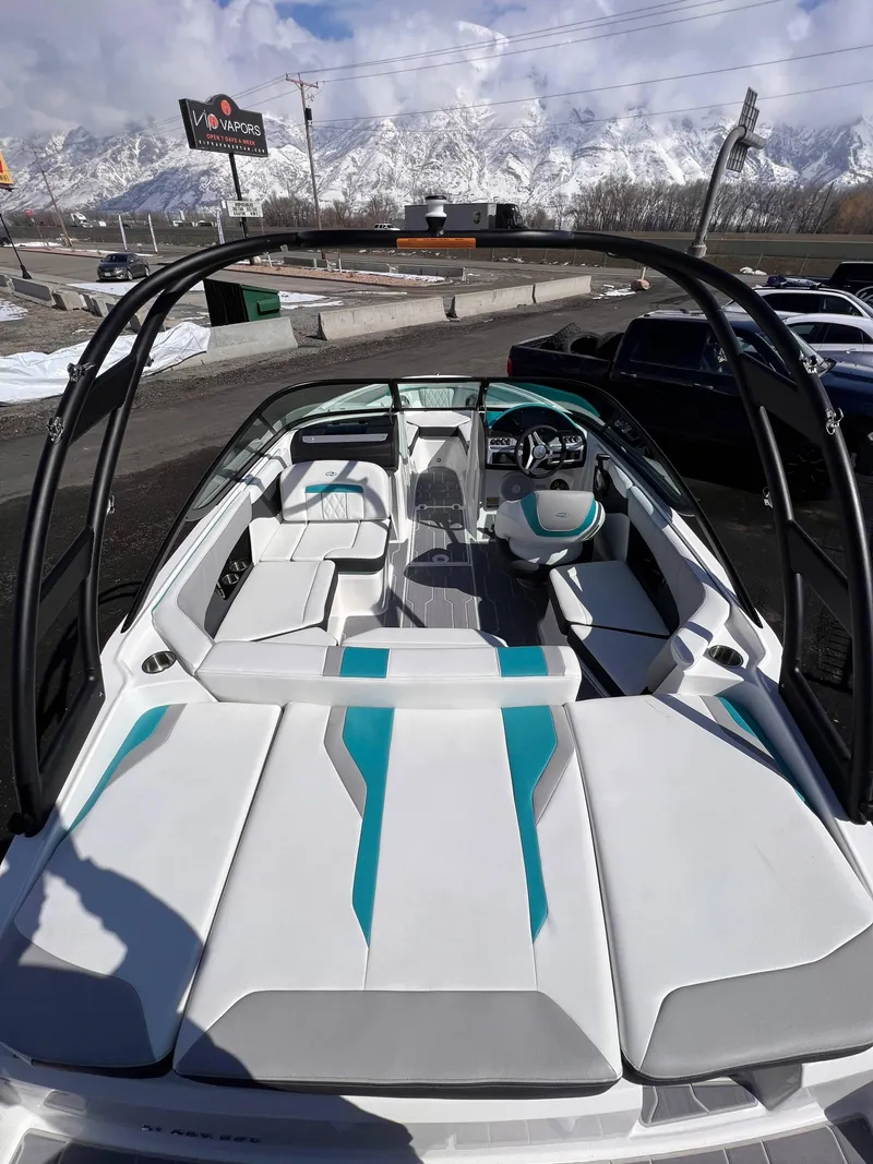 Slide: The Image of 2023 Regal 21 OBX boat interior with white and teal seating, mountain backdrop. - 15