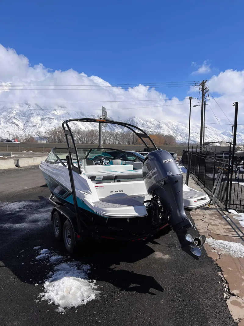 Slide: The Image of 2023 Regal 21 OBX boat with Yamaha engine, parked on snowy pavement, mountain backdrop. - 17