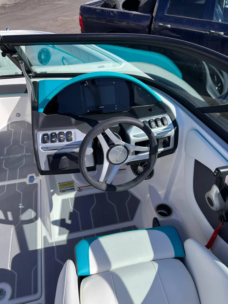 Slide: The Image of 2023 Regal 21 OBX boat cockpit with modern steering wheel and control panel. - 19
