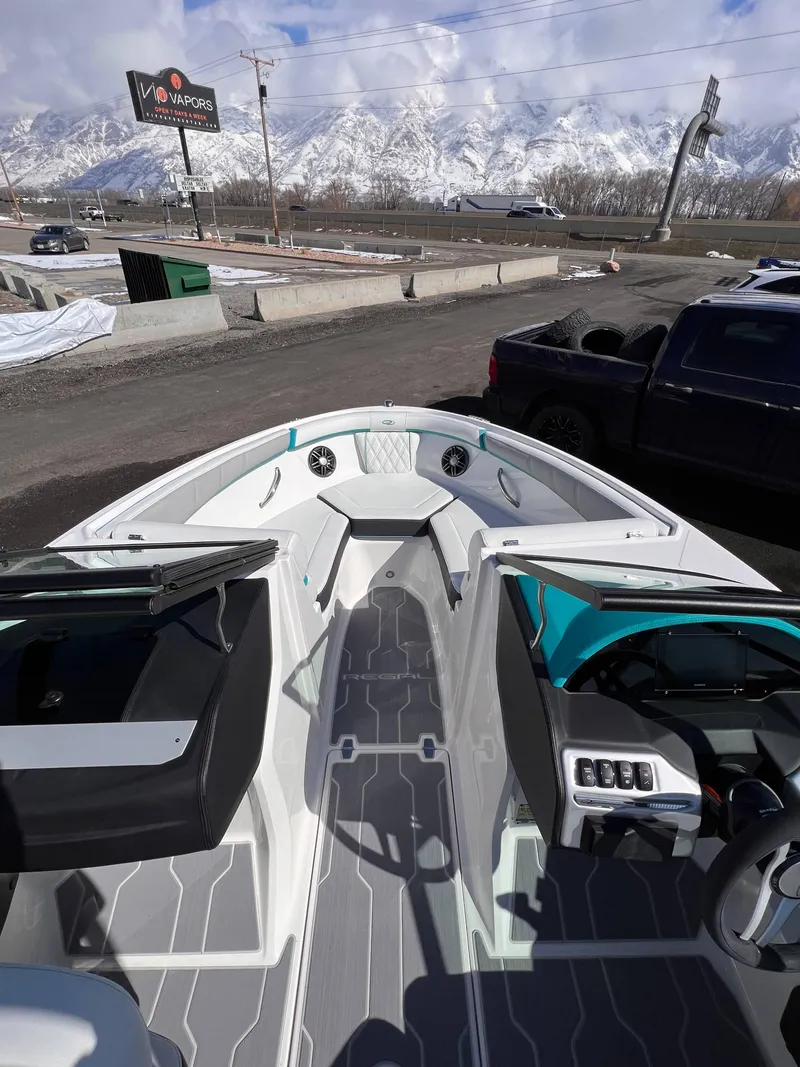 Slide: The Image of 2023 Regal 21 OBX boat interior with modern design, parked near snowy mountains. - 20