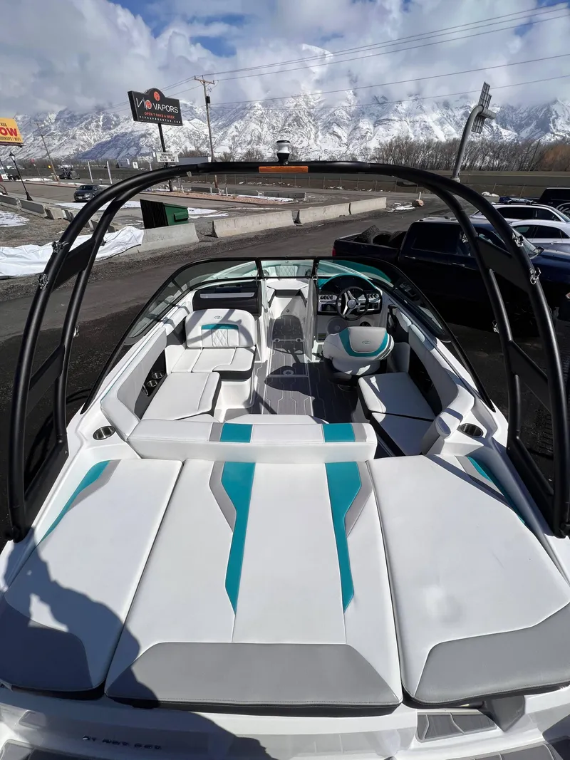 Slide: The Image of 2023 Regal 21 OBX boat interior with white and teal seating, mountain backdrop. - 21