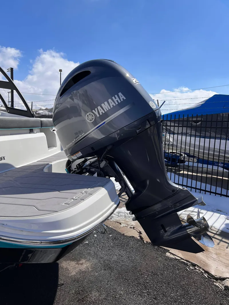 Slide: The Image of 2023 Regal 21 OBX boat with Yamaha outboard motor, parked outdoors. - 22