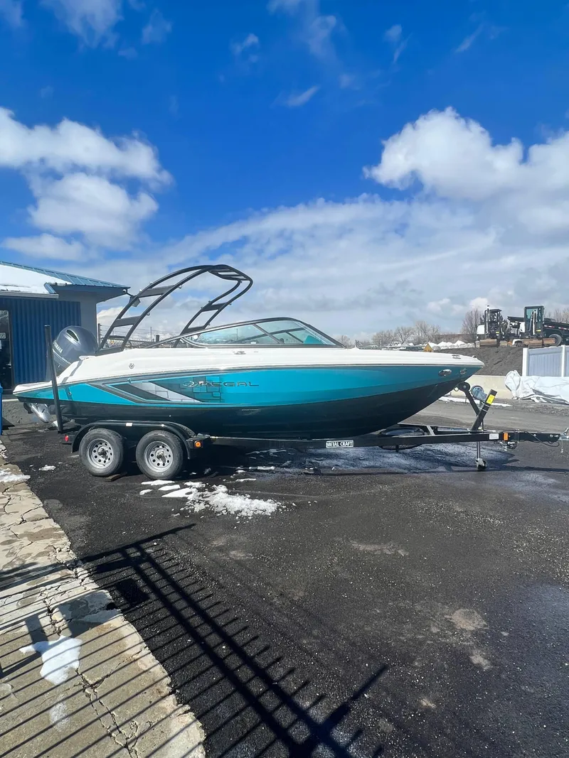 Slide: The Image of 2023 Regal 21 OBX boat on trailer under blue sky. - 4