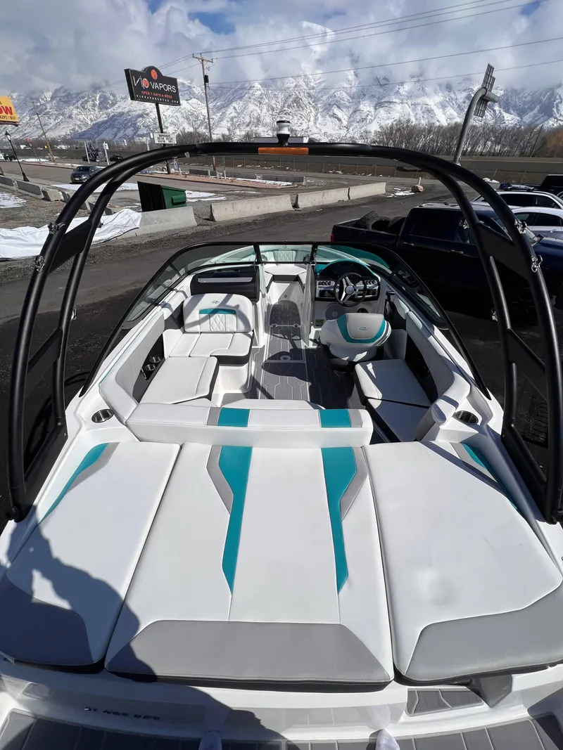 Slide: The Image of 2023 Regal 21 OBX boat interior with teal accents, mountain backdrop, and clear sky. - 9