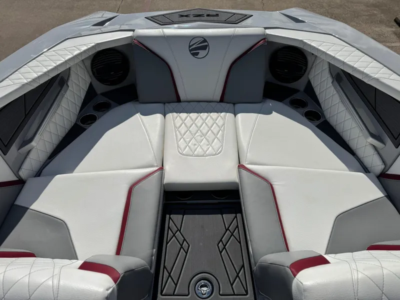 Slide: The Image of 2023 Tigé 22RZX boat interior with white and red upholstery, featuring cup holders and speakers. - 19