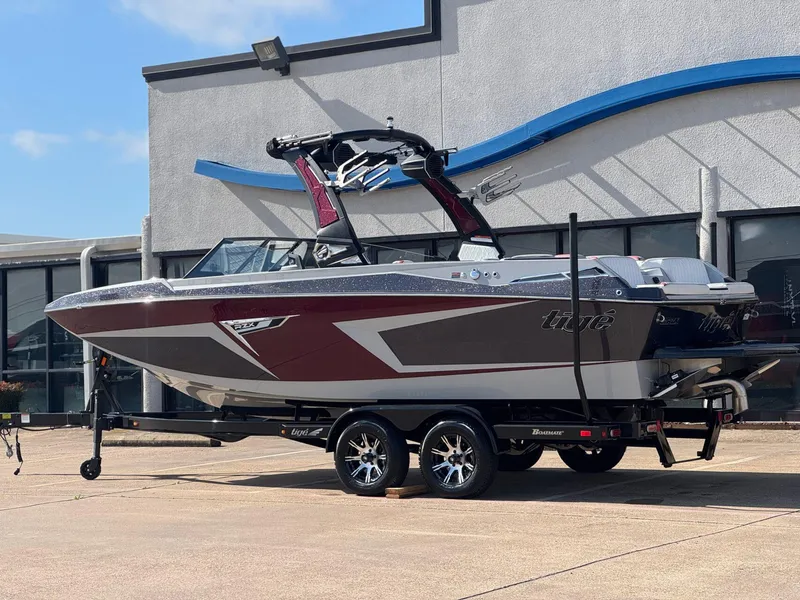 Slide: The Image of 2023 Tigé 22RZX boat on trailer, parked outside a building. - 3