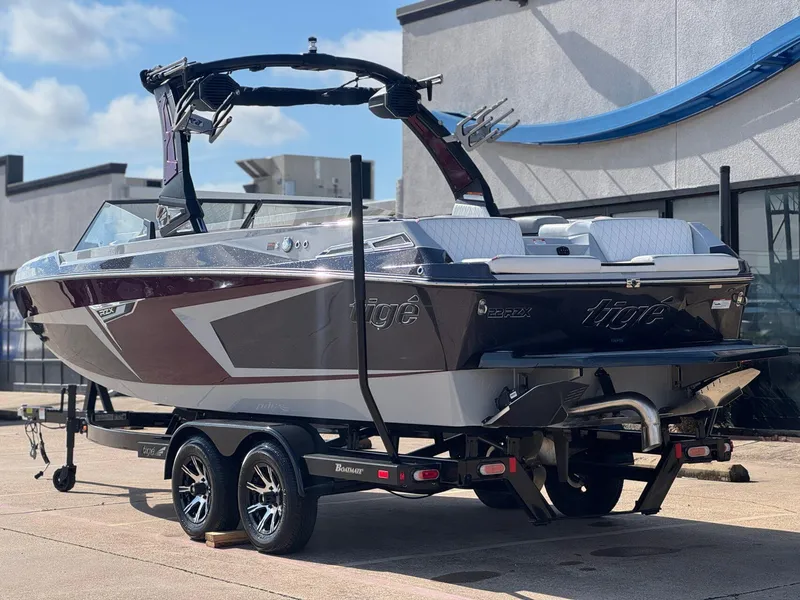 Slide: The Image of 2023 Tigé 22RZX boat on trailer, sleek design, parked outdoors. - 4