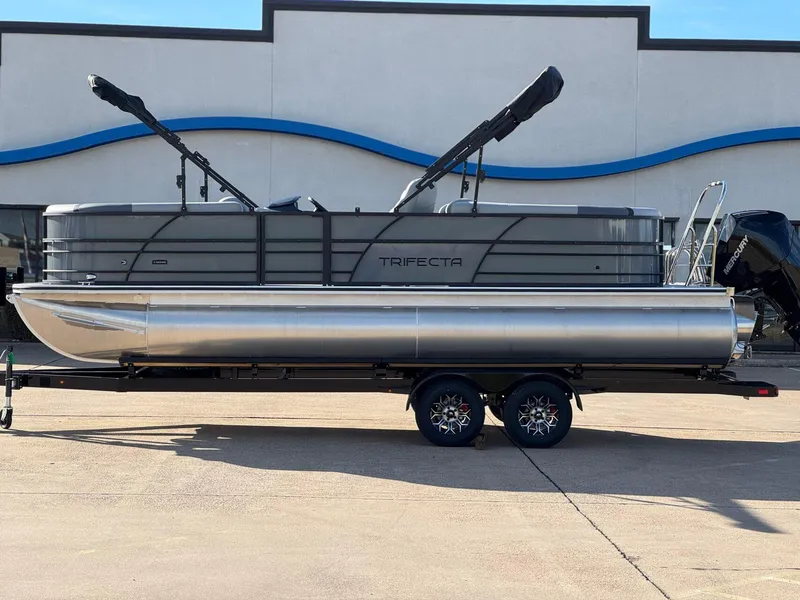 Slide: The Image of 2025 Trifecta 24RF CS 3.0 pontoon boat on trailer, side view. - 1