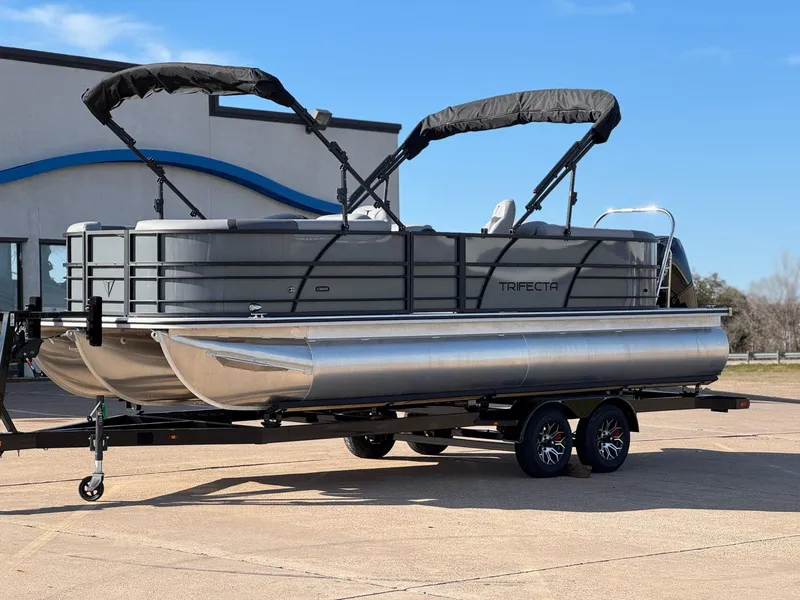 Slide: The Image of 2025 Trifecta 24RF CS 3.0 pontoon boat on trailer, parked outdoors. - 8