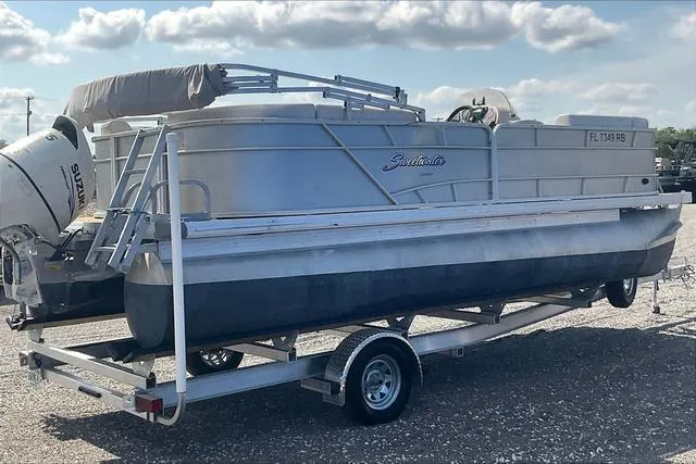 Slide: The Image of 2016 Sweetwater SW 2286 pontoon boat on trailer, parked outdoors under cloudy sky. - 7