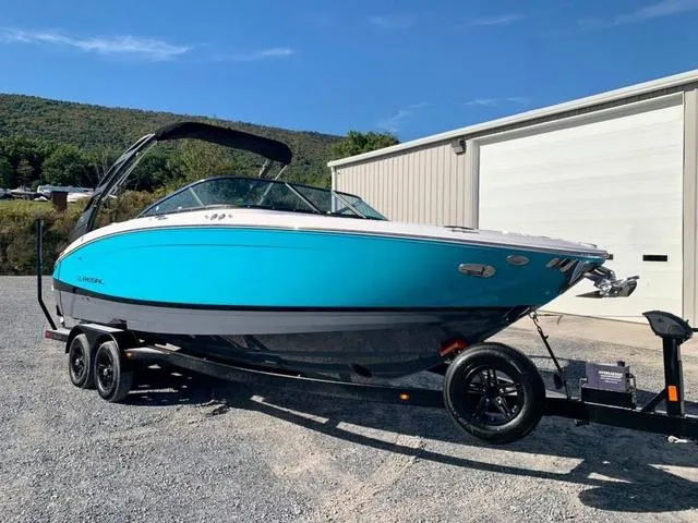 Slide: The Image of 2022 Regal LS6 boat on trailer, vibrant blue hull, parked outdoors. - 3