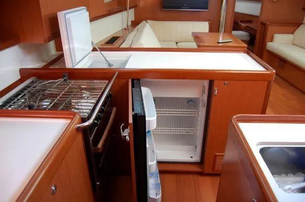 Slide: The Image of Interior of 2008 Beneteau Oceanis 49 yacht kitchen with fridge, stove, and seating area. - 10