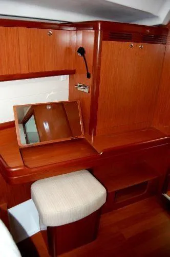 Slide: The Image of 2008 Beneteau Oceanis 49 yacht interior with wooden vanity and cushioned stool. - 12