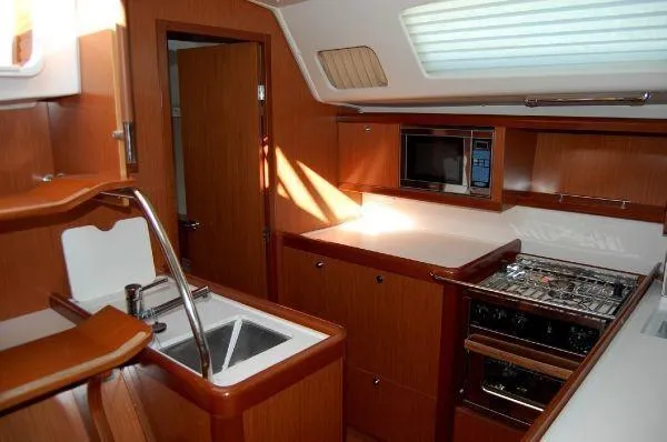 Slide: The Image of Interior of 2008 Beneteau Oceanis 49 yacht kitchen with wood finish and modern appliances. - 9