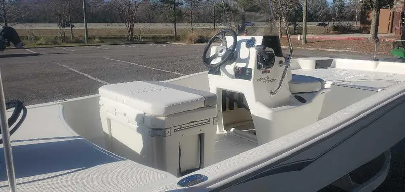 Slide: The Image of 2025 Mako Pro Skiff 15 CC boat in a parking lot, showcasing interior and console. - 2
