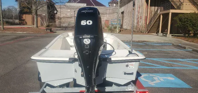Slide: The Image of 2025 Mako Pro Skiff 15 CC boat with 50 HP engine in a parking lot. - 3