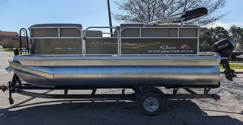 The Image of 2025 Sun Tracker Party Barge 16 DLX pontoon boat on trailer, parked outdoors. - 0