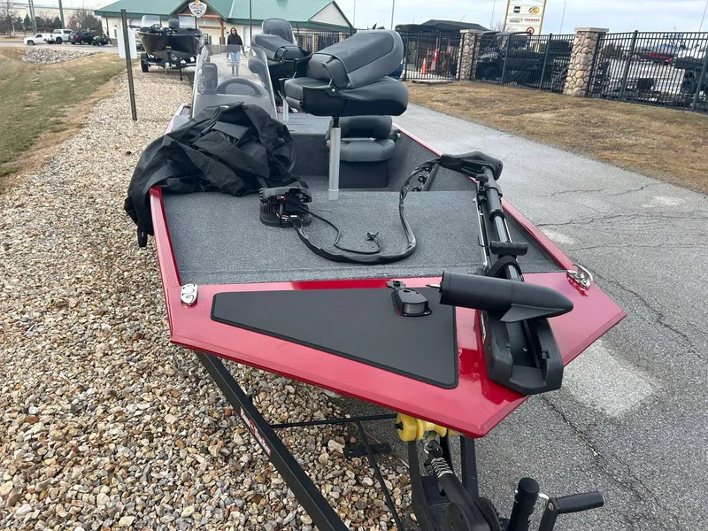 Slide: The Image of 2025 Tracker Bass Tracker Classic XL boat with red trim, parked on gravel. - 6