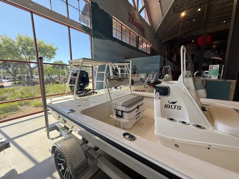 Slide: The Image of 2025 Mako 18 LTS boat displayed indoors with natural light streaming through windows. - 2