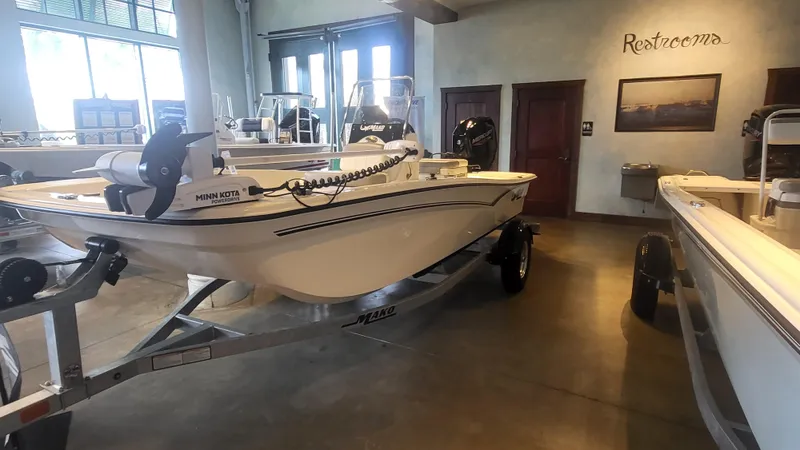 Slide: The Image of 2025 Mako Pro Skiff 15 CC boat displayed indoors on a trailer. - 3