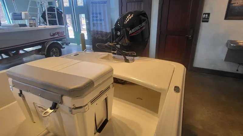 Slide: The Image of 2025 Mako Pro Skiff 15 CC boat interior with Mercury engine in showroom. - 4