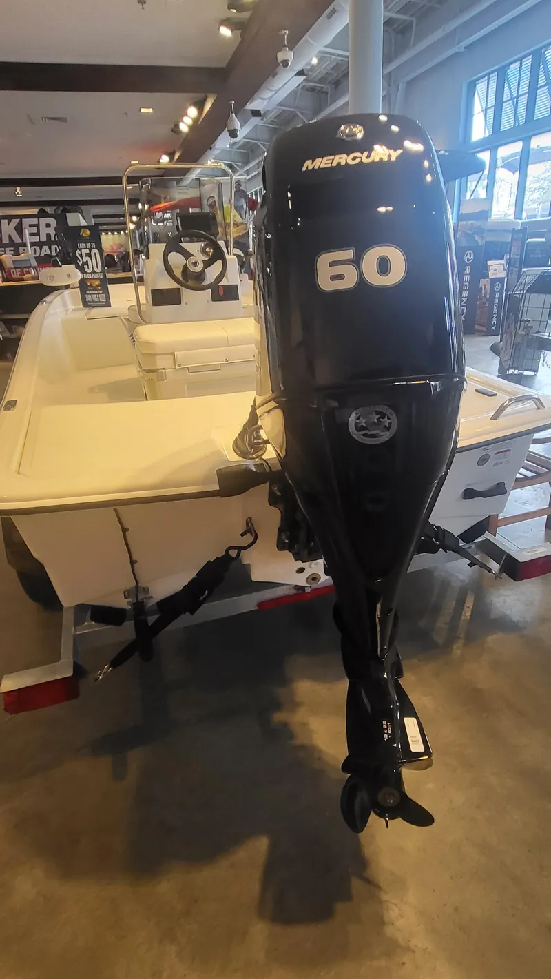 Slide: The Image of 2025 Mako Pro Skiff 15 CC with Mercury 60 engine displayed indoors. - 5