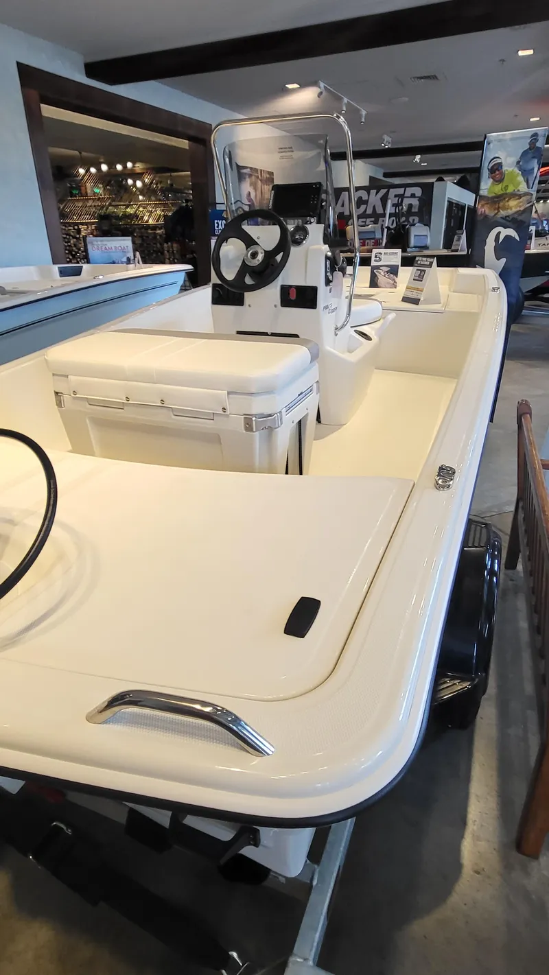 Slide: The Image of 2025 Mako Pro Skiff 15 CC boat displayed in showroom, featuring center console design. - 8
