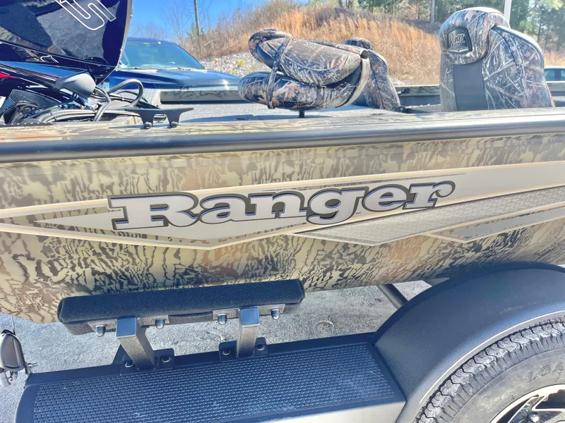 Slide: The Image of 2025 Ranger RT188 boat with camouflage design and logo, parked outdoors. - 17