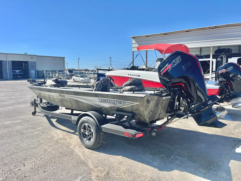 Slide: The Image of 2025 Ranger RT188 boat with powerful outboard motor on trailer in sunny dealership lot. - 2