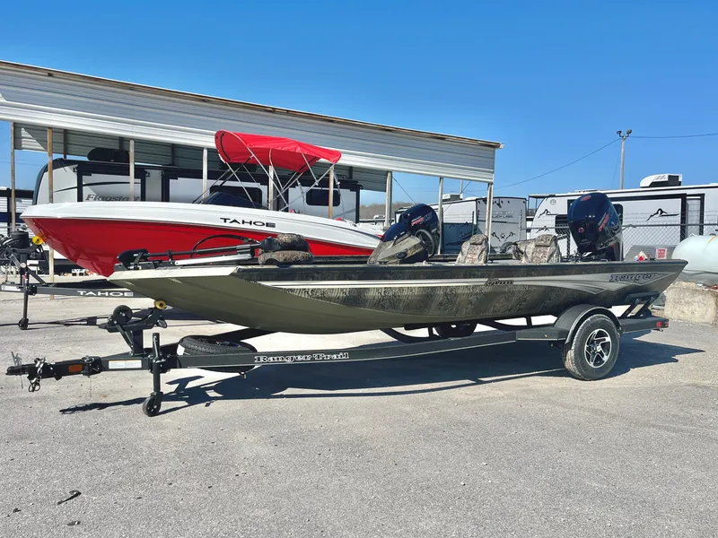 Slide: The Image of 2025 Ranger RT188 boat on trailer, parked outdoors, with a red and white boat in background. - 3