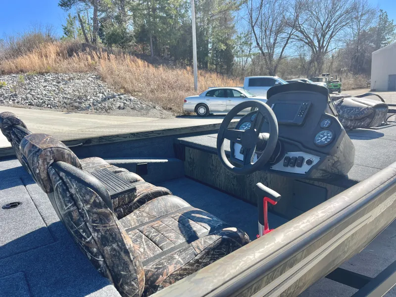 Slide: The Image of 2025 Ranger RT188 boat interior with camo seats and steering console in outdoor setting. - 6