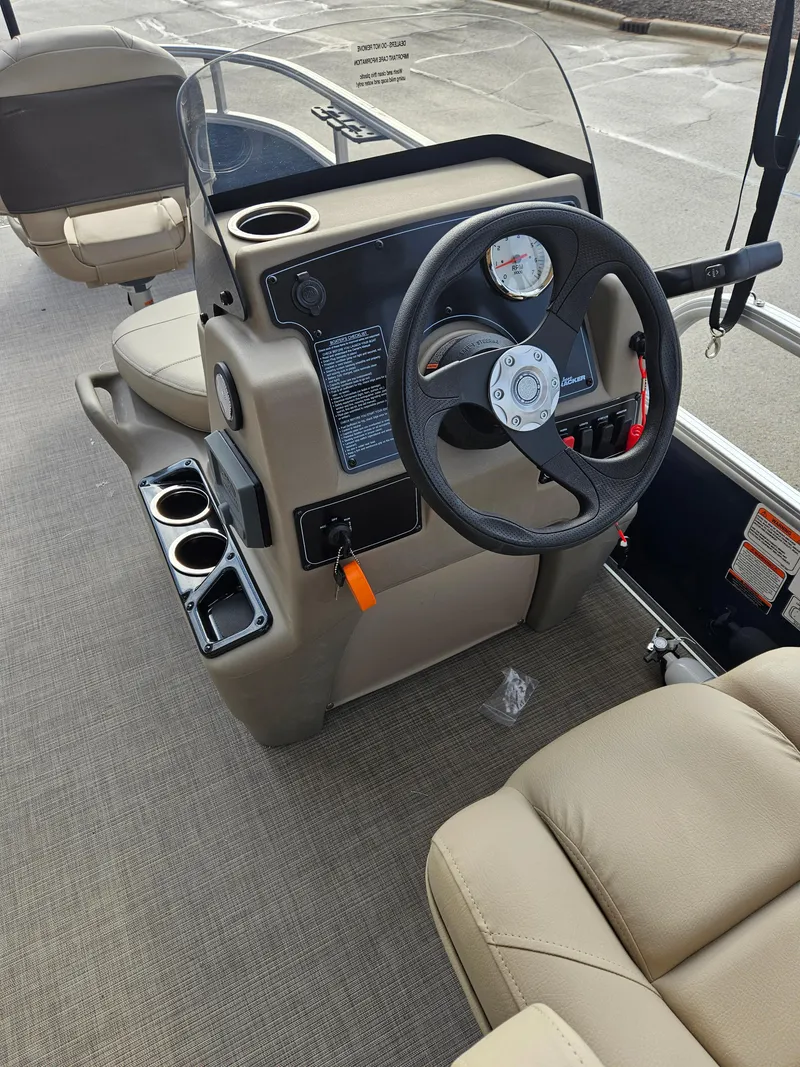 Slide: The Image of 2025 Sun Tracker Bass Buggy 16 XL Select boat interior with steering wheel and seating. - 4