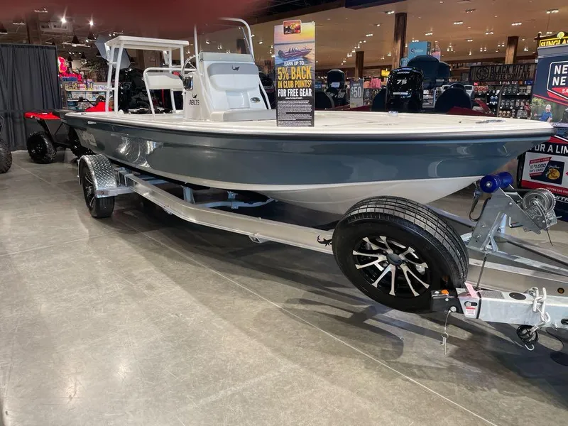 Slide: The Image of 2025 Mako 18 LTS boat on display in showroom with trailer. - 0