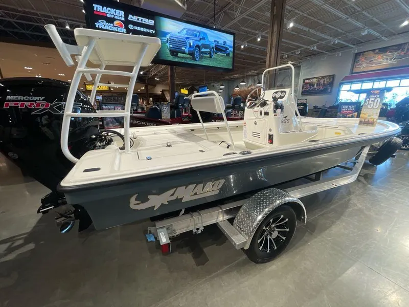 Slide: The Image of 2025 Mako 18 LTS boat on display in showroom with trailer. - 1