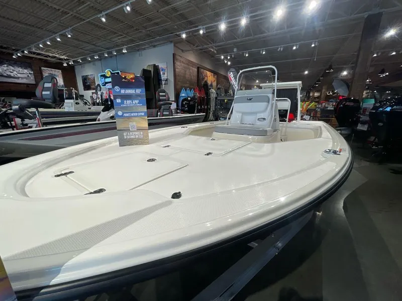 Slide: The Image of 2025 Mako 18 LTS boat displayed in a showroom with bright overhead lighting. - 2