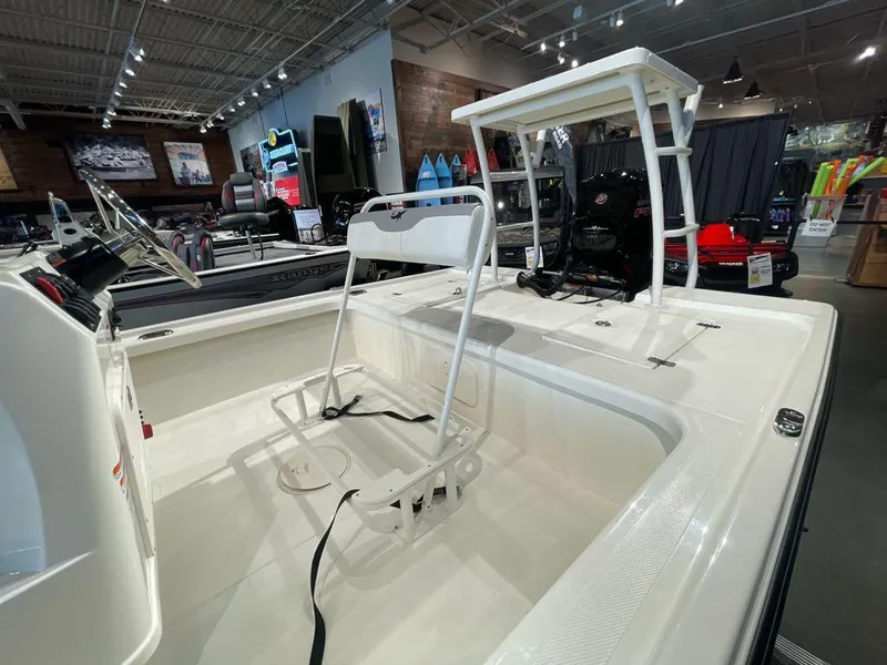 Slide: The Image of 2025 Mako 18 LTS boat interior with seating and steering wheel in showroom. - 4