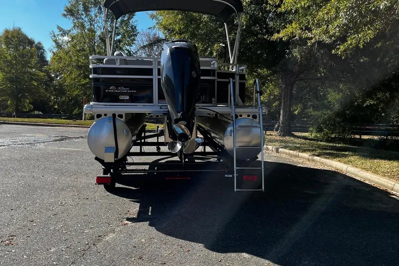 Slide: The Image of 2025 Sun Tracker SportFish 20 DLX pontoon boat on trailer, parked outdoors. - 4